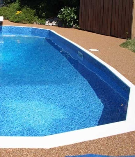 Backyard pool with a new patterned liner, white coping, and an aggregate deck